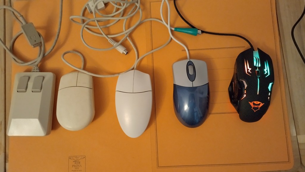 Collezione di mouse: da sinistra verso destra: Commodore Tank Mouse, Mouse per Amiga 1200, mouse no brand PS2, mouse no brand PS2 con scroller, mouse moderno